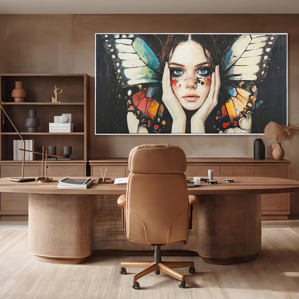 Tablou canvas cu tablou canvas cu femeie si aripi de fluture, in rama de aluminiu argintiu, pe perete intr-un birou